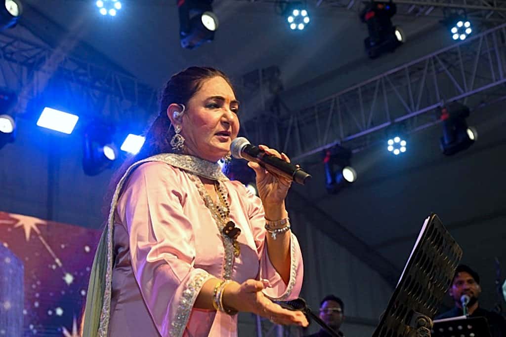 Close-up of a female vocalist mid-performance under stage spotlights